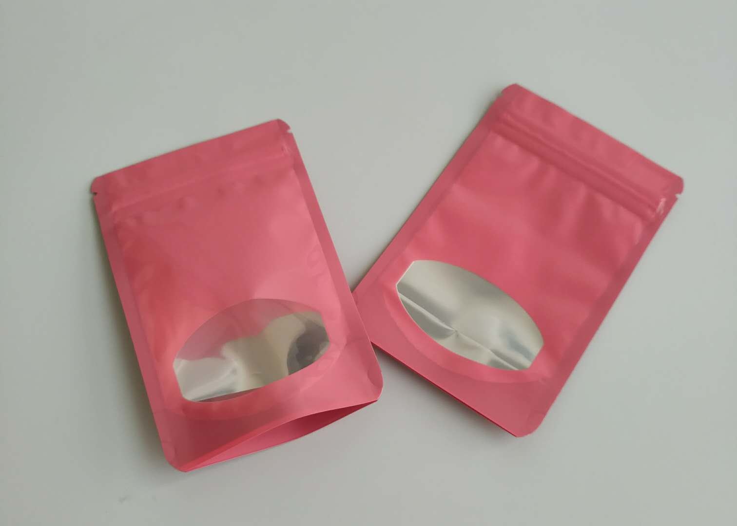 Sacchetti di plastica di colori differenti che imballano chiaramente le borse di Candy della frutta del cioccolato con la finestra